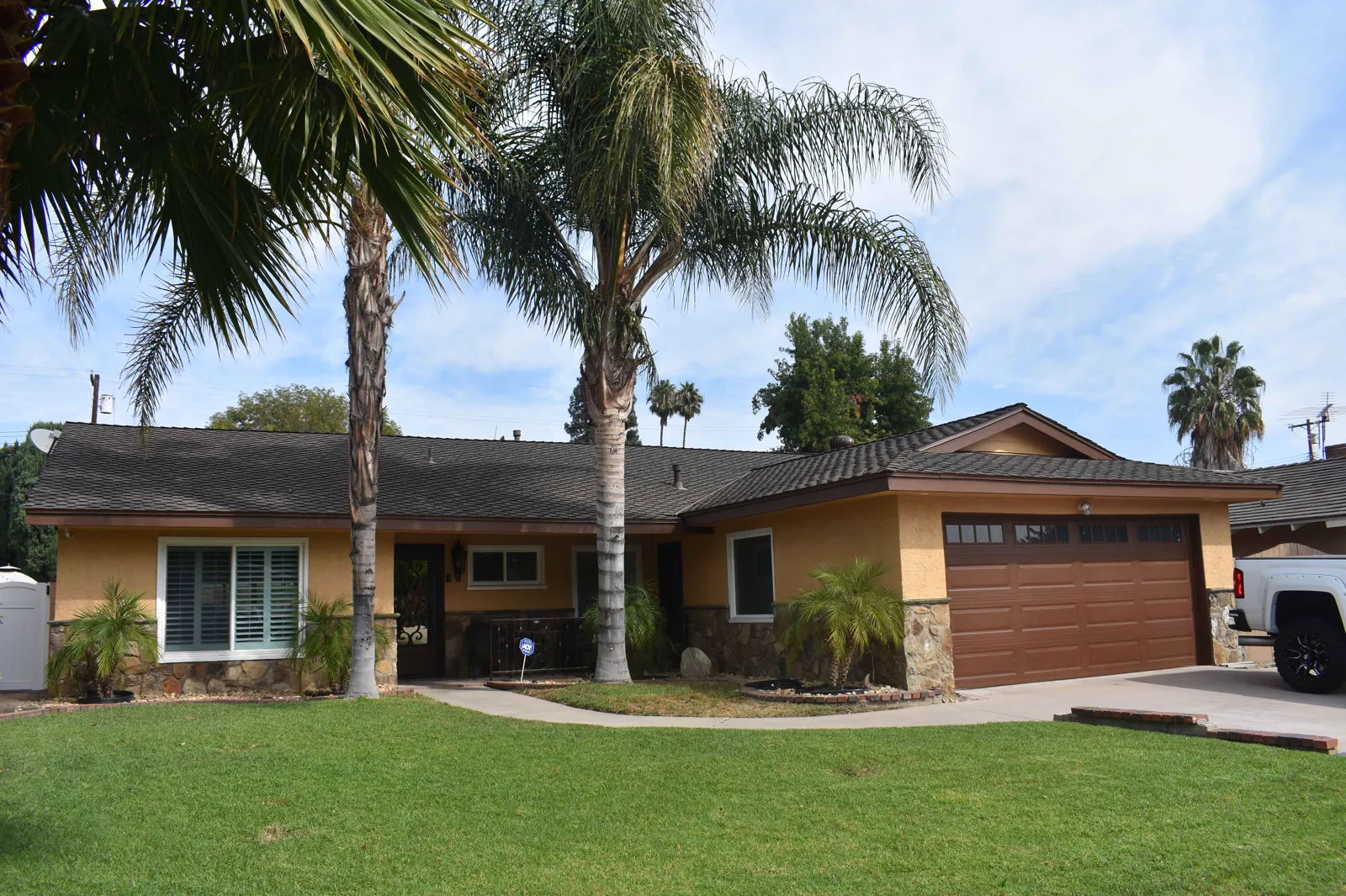 Freshly painted single-story home with palms