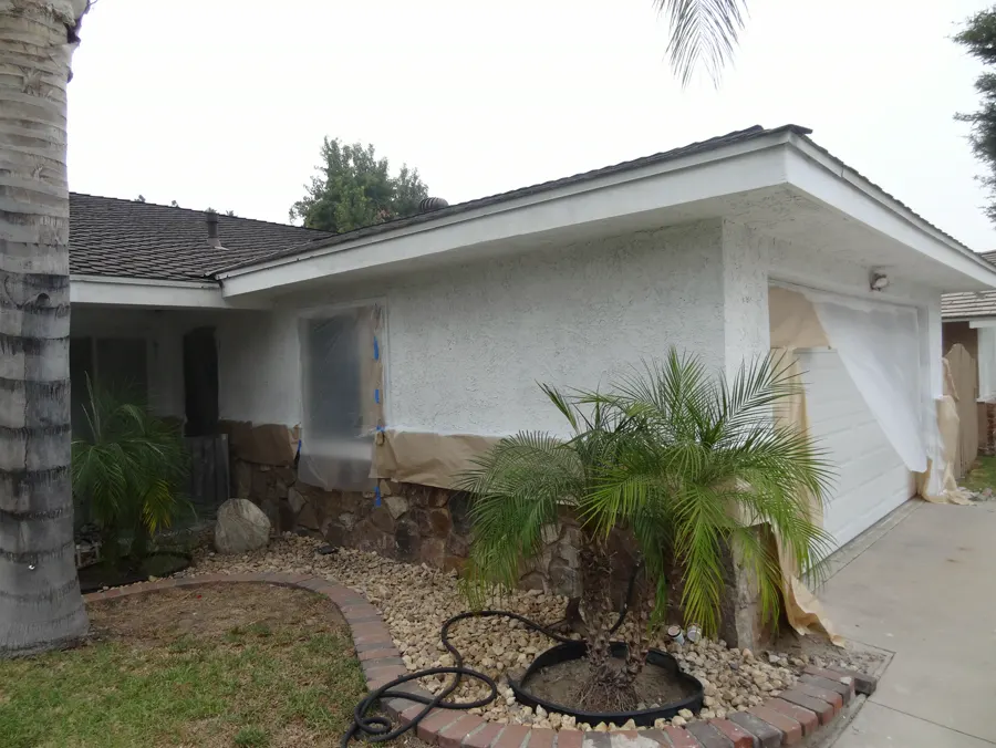 Single-story stucco home with a fresh finish and a planted front bed