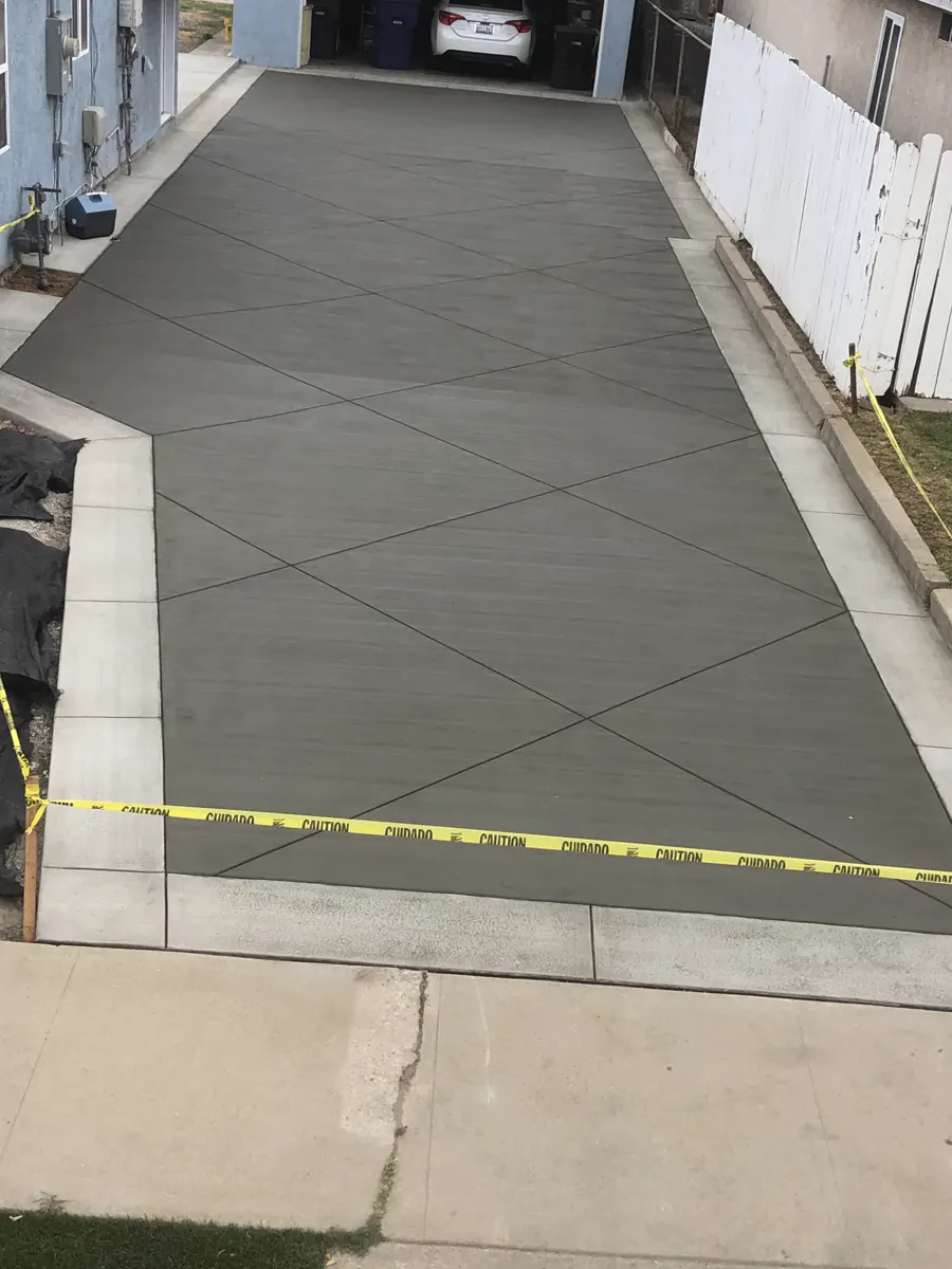 A freshly poured side yard slab with taped-off edges
