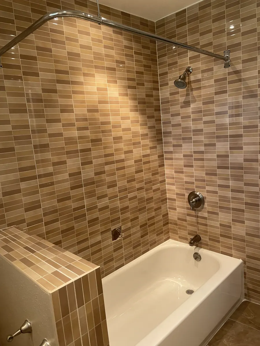 A bathtub surround in wood-look plank tile