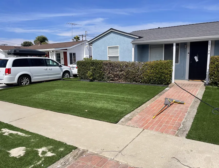 A red brick paver walk through new turf in a front yard